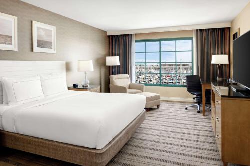 a hotel room with a large white bed and a desk at DoubleTree by Hilton San Pedro in San Pedro