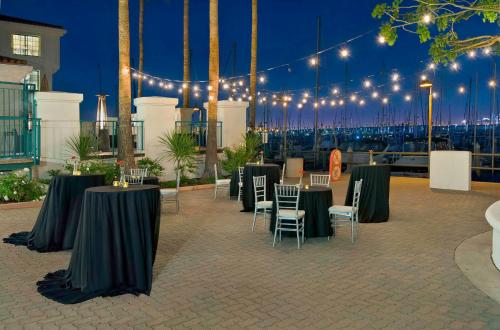 a group of tables and chairs on a patio with lights at DoubleTree by Hilton San Pedro in San Pedro