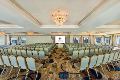 a room with rows of chairs and a projection screen at DoubleTree by Hilton San Pedro in San Pedro
