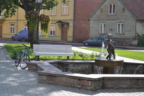 a statue of a bird sitting on a fountain next to a bench at Lossikambri külaliskorterid in Viljandi