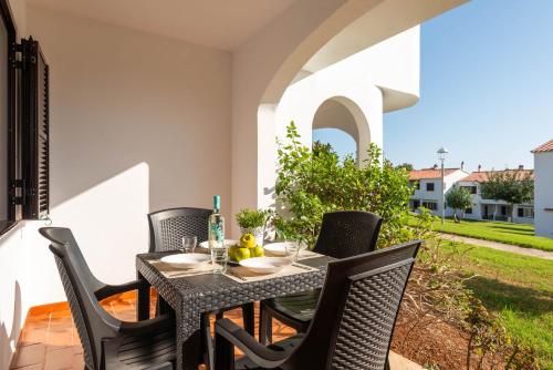 a patio with a table and chairs on a balcony at Apartamentos en Son Bou in Son Bou