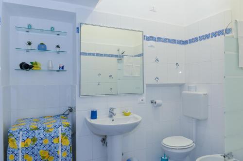 a white bathroom with a sink and a toilet at Casa Natalia in Sorrento