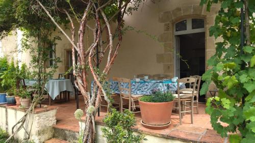 a patio with a table and chairs in a garden at Le Gavachon in Leboulin
