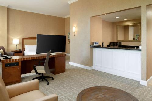 a hotel room with a bed and a desk with a computer at Hilton Charlotte Uptown in Charlotte