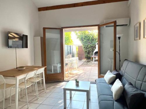 een woonkamer met een bank en een tafel bij Idéal pour vos vacances a in Aigues-Mortes