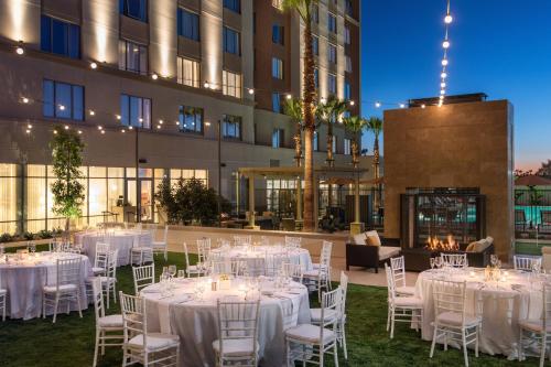 a room with white tables and chairs in front of a building at Courtyard by Marriott Irvine Spectrum in Irvine