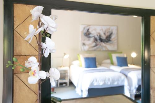a bedroom with two beds and a mirror at Notting Hill Lodge in Nottingham Road