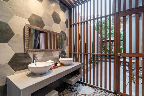łazienka z 2 umywalkami i lustrem w obiekcie The Nani w mieście Ubud