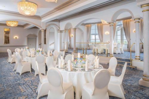 a banquet hall with white tables and white chairs at Hilton Dresden an der Frauenkirche in Dresden