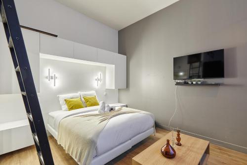 une chambre avec un lit et une télévision sur un mur dans l'établissement Studio Jardin du Luxembourg by Studio prestige, à Paris