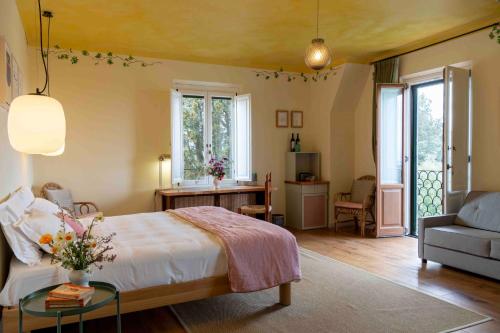 a bedroom with a bed and a couch and a table at Villa Lena in Palaia