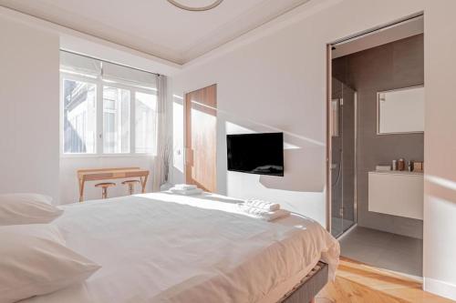 une chambre blanche avec un lit et une télévision dans l'établissement Champs Elysées Stylish Flat 2BR 6PPL, à Paris