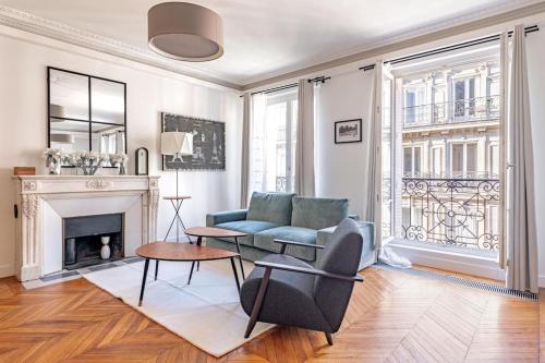 un salon avec un canapé bleu et une cheminée dans l'établissement Champs Elysées Stylish Flat 2BR 6PPL, à Paris