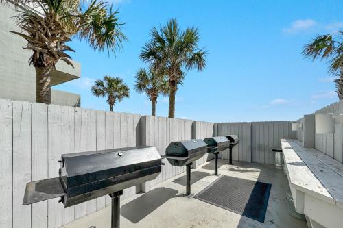 two bbqurgers on a patio next to a fence at San Carlos Unit 607 in Gulf Shores