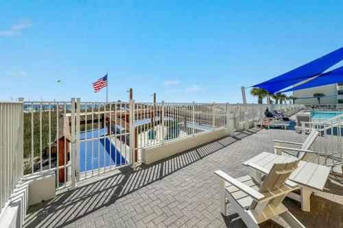 a patio with a pool and chairs and a fence at San Carlos Unit 607 in Gulf Shores
