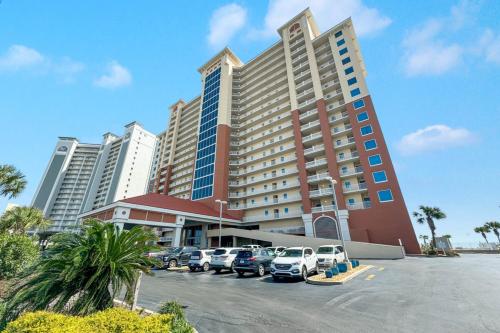 a large building with cars parked in a parking lot at San Carlos Unit 607 in Gulf Shores