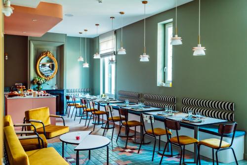 a row of tables and chairs in a restaurant at Hôtel Maison Lacassagne Lyon in Lyon