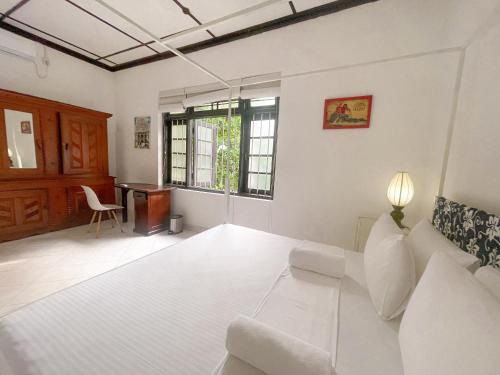 uma sala de estar com um sofá branco e uma secretária em Lost & Found - Colombo em Colombo