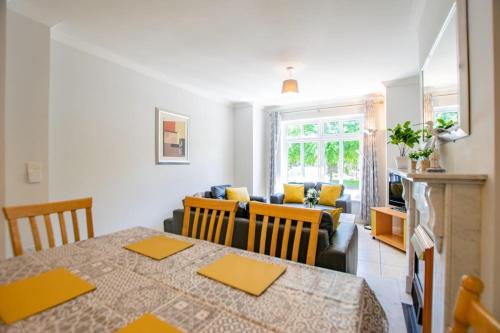 a living room with a table and a couch at 74 - 4 Bed Townhouse With Parking by Shortstays in Galway