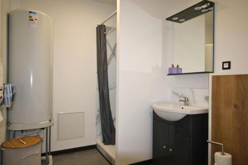 a white bathroom with a sink and a shower at La brique Rouge, 5P Parking in Noeux-les-Mines