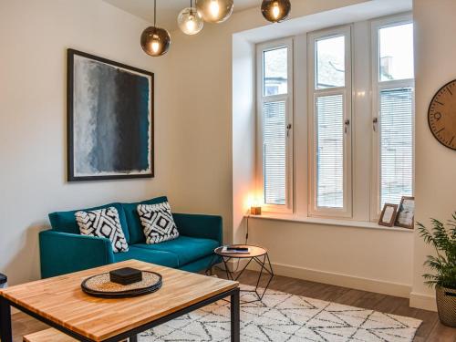 a living room with a blue couch and a table at 'The Kepties' Luxurious Serviced Apartments in Arbroath