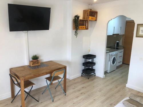 un salon avec une table et une télévision sur un mur dans l'établissement Incredible Apartment, à Alicante