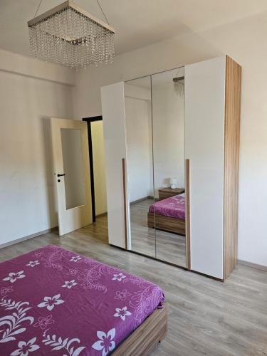 1 dormitorio con cama y armario con espejo en Appartamento vicino università, en Piacenza