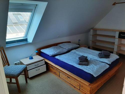1 dormitorio con cama con sábanas azules y ventana en Obere Sonnsibar, en Fehmarn