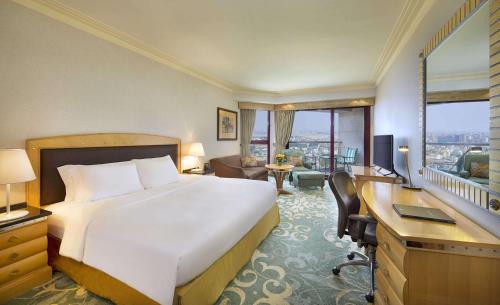 a hotel room with a bed and a desk and a room with a bed at Jeddah Hilton in Jeddah