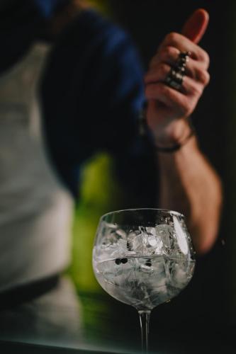a glass of water with a hand holding a cigar at Derlon Hotel Maastricht in Maastricht