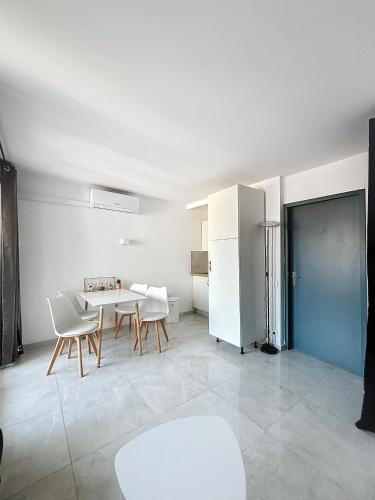 une cuisine avec une table, des chaises et un réfrigérateur dans l'établissement Résidence Graziella Studio 424, à Juan-les-Pins