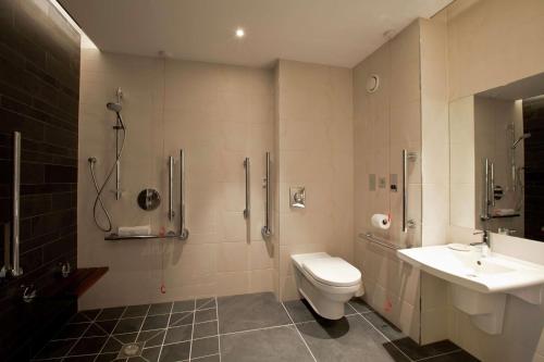 a bathroom with a toilet and a shower and a sink at Hilton London Heathrow Airport Terminal 5 in Hillingdon