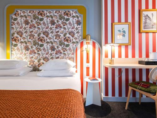 1 dormitorio con cama y pared de rayas rojas y blancas en Mercure Paris Notre Dame Saint Germain des Prés, en París