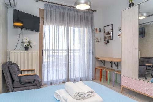 sala de estar con silla y ventana en Kosmos Service Apartment Beautiful Studio 3 With Additional Cost Parking, en Tesalónica