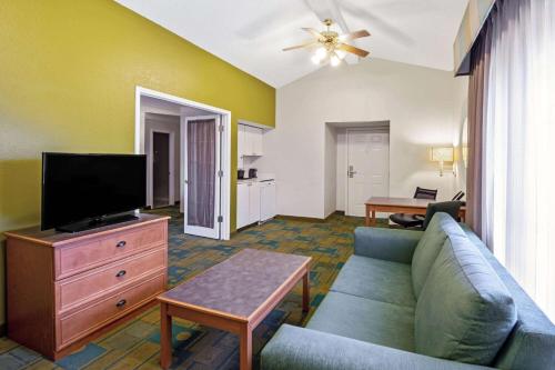 a living room with a couch and a flat screen tv at La Quinta Inn by Wyndham Amarillo Mid-City in Amarillo