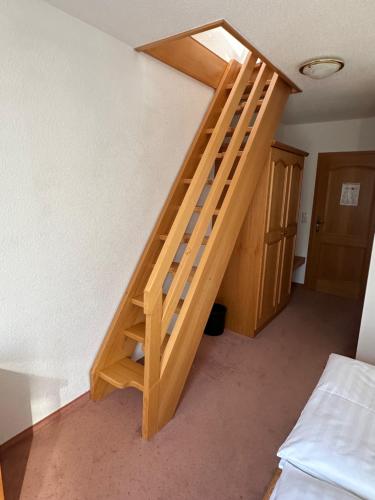 a wooden staircase in a room with a bed at Hotel am Spreebogen in Burg