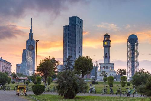 um horizonte da cidade com edifícios altos e uma torre do relógio em ORBI CITY sea em Batumi