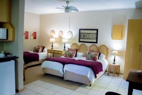 a bedroom with two beds and a ceiling at Fisant, Bokmakierie and Hoephoep Guest House in Bethlehem