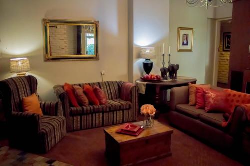 a living room with two couches and a table at Fisant, Bokmakierie and Hoephoep Guest House in Bethlehem