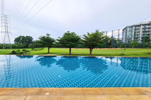 a large swimming pool with trees in the background at The Par Phuket SHA Plus in Kathu