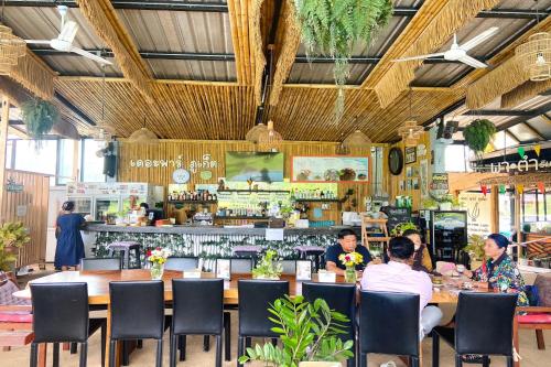 a group of people sitting at tables in a restaurant at The Par Phuket SHA Plus in Kathu