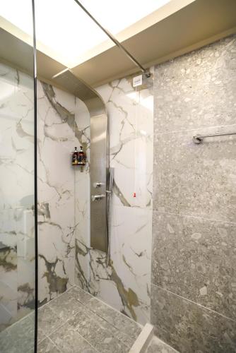 a bathroom with a shower with a stone wall at Anthidon Nature Estate & Farm in Chalkida