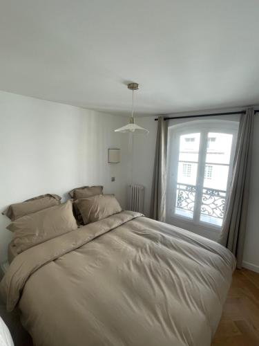 une chambre blanche avec un grand lit avec une fenêtre dans l'établissement Appartement Neuf à 500m des Champs-Élysées, à Paris