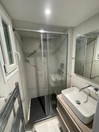 une salle de bain avec douche et lavabo dans l'établissement Appartement Neuf à 500m des Champs-Élysées, à Paris