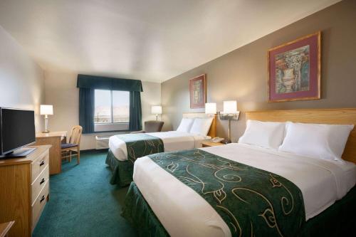 a hotel room with two beds and a television at Travelodge by Wyndham Yermo in Yermo