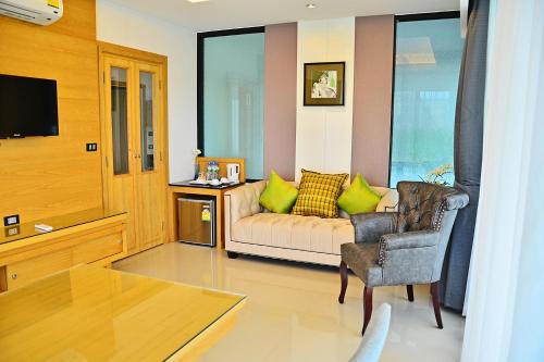 a living room with a couch and a chair at The Par Phuket SHA Plus in Kathu
