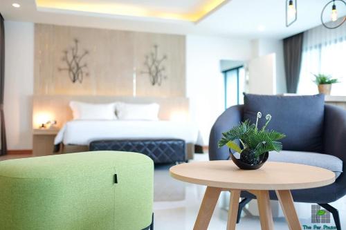 a room with a bed and a table and a couch at The Par Phuket SHA Plus in Kathu