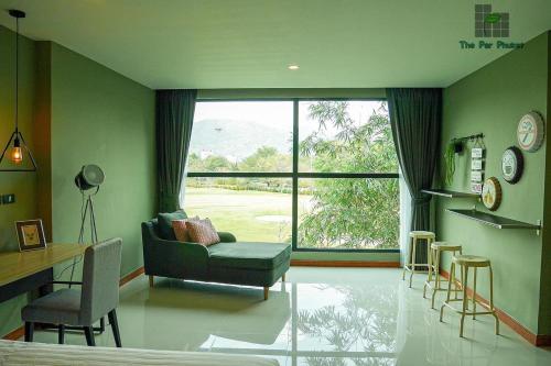a living room with a couch and a chair and a window at The Par Phuket SHA Plus in Kathu