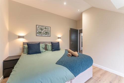 - une chambre avec un grand lit et des oreillers bleus dans l'établissement Stylish 1 Bedroom Apartments Free Parking Good Location, à Derby