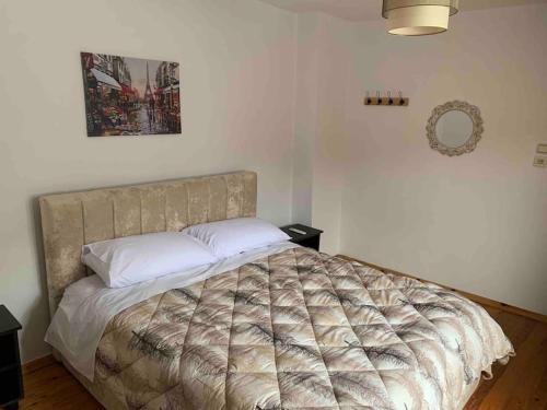 a bedroom with a large bed with a comforter at Traditional Bazaar Home2 in Korçë